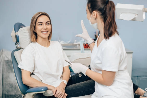 Smiling patient and dentist discussing treatment in a dental clinic. -general dentistry services